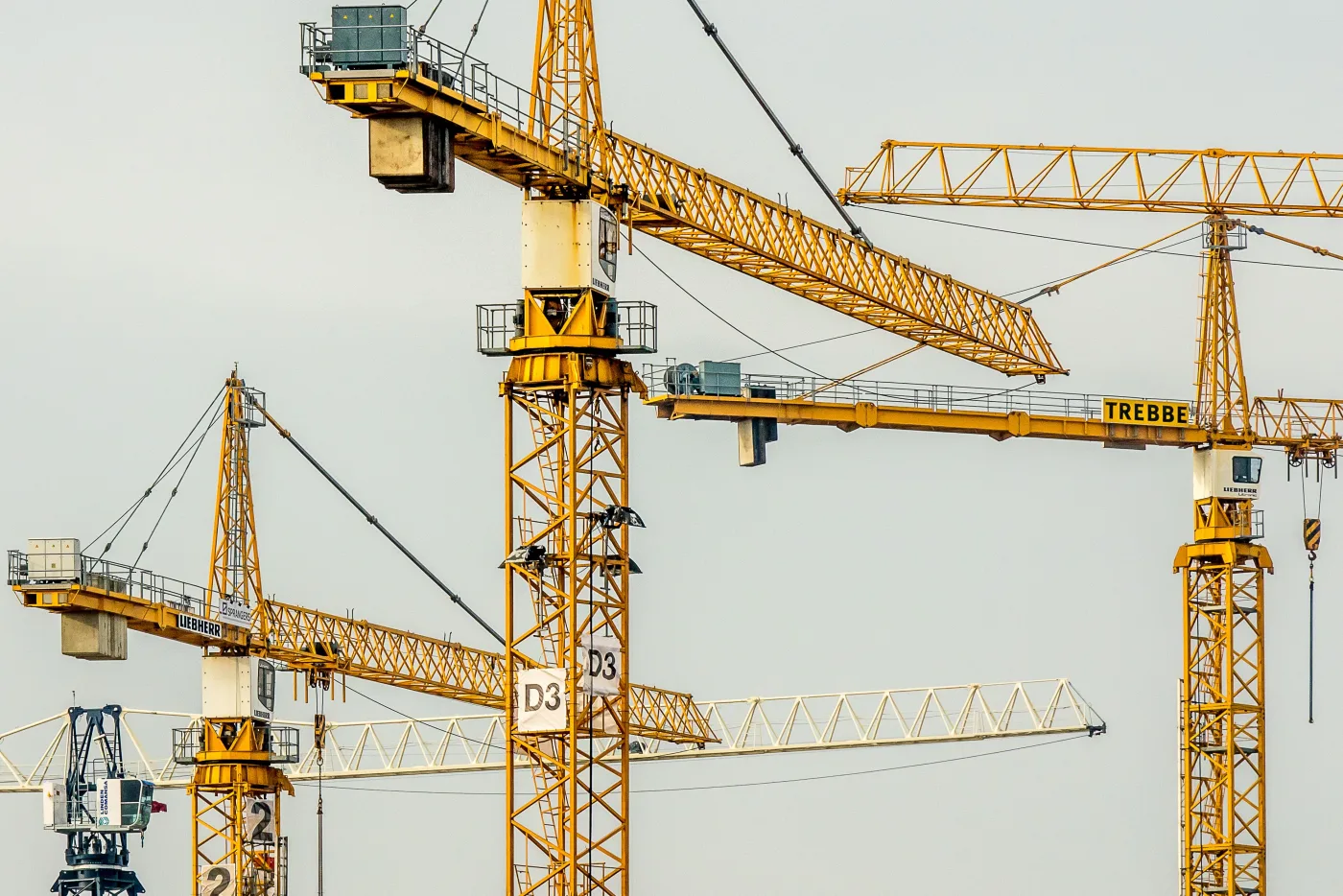 Żółte dźwigi budowlane na tle jasnego nieba